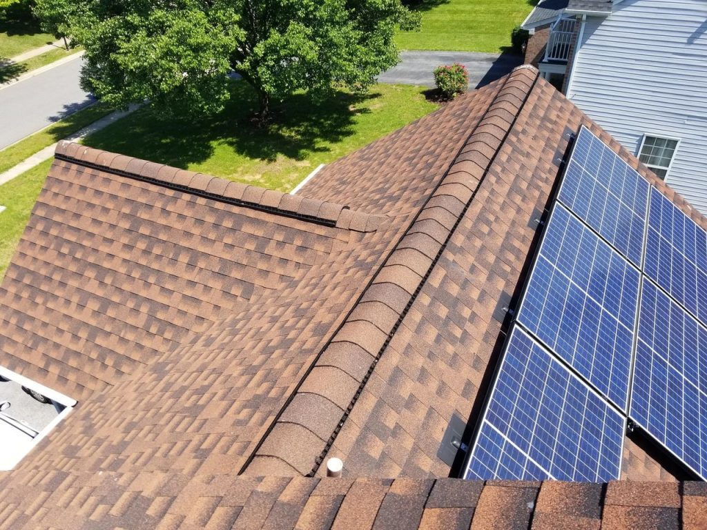 Roof with solar panels and shingles